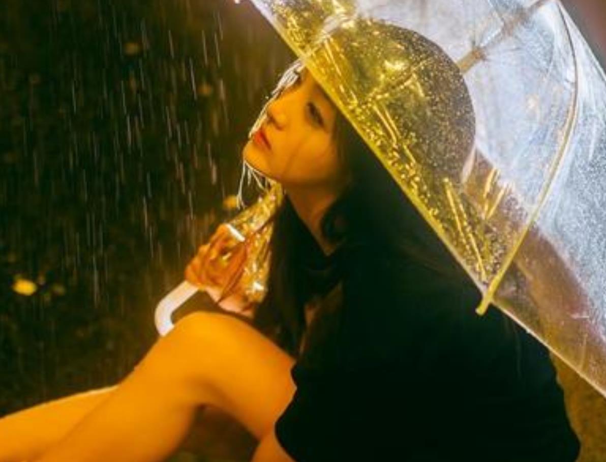 女人雨中撑伞伤心图片